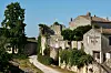 Ancient stone buildings and a winding path in a sunlit rural village
