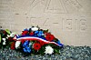 Floral wreaths with French tricolour ribbons rest at a Verdun memorial marked 1918.