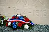 Floral wreaths with French tricolour ribbons rest at a Verdun memorial marked 1918.