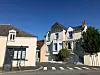 19th-century houses line a quiet street in Déols, Indre, with a zebra crossing and blue sky.
