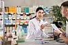 Female pharmacist assisting a young male customer at a pharmacy counter