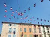 French flags strung above colourful village houses in Cuers, Provence-Alpes-Côte d’Azur